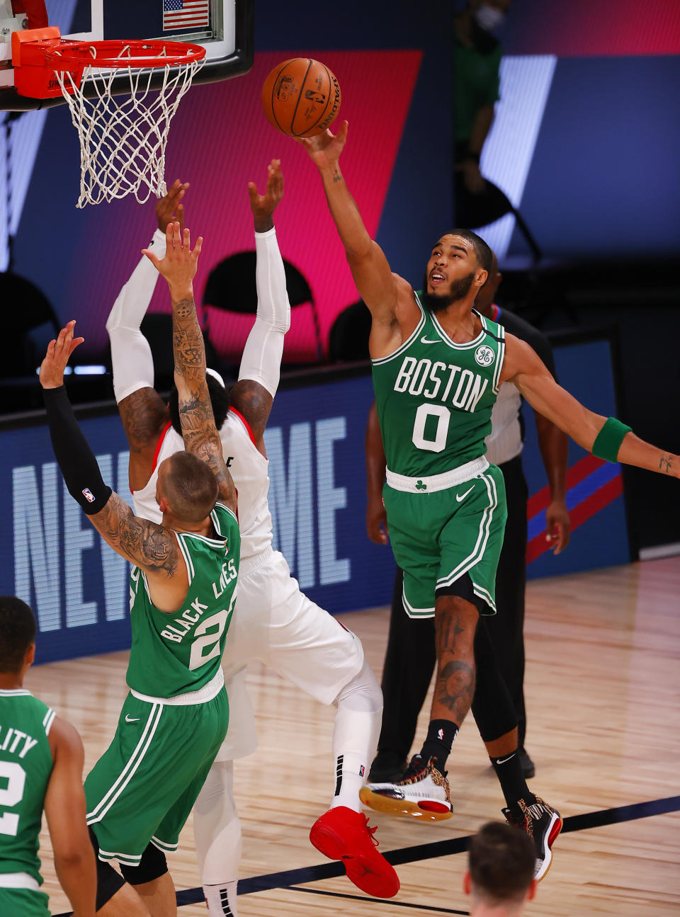 Portland Trail Blazers' Carmelo Anthony, center, goes up to shoot against Boston Celtics' Jayson Tatum (0) during an NBA basketball game Sunday, Aug. 2, 2020, in Lake Buena Vista, Fla. (Mike Ehrmann/Pool Photo via AP)