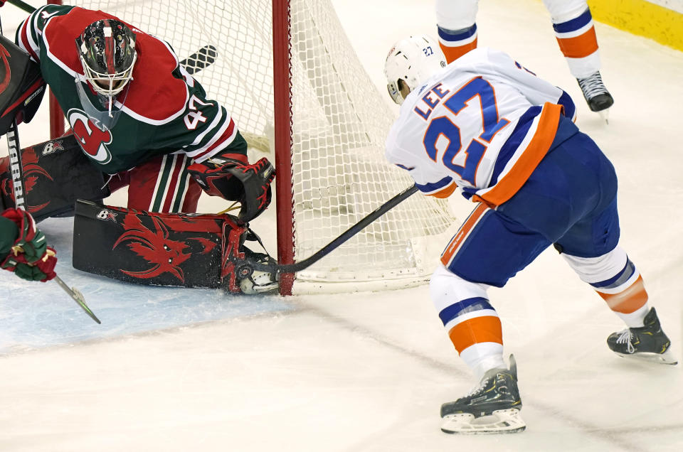 New York Islanders left wing Anders Lee (27) tries to get the puck past the pads of New Jersey Devils goaltender Aaron Dell (47) during the second period of an NHL hockey game, Tuesday, March 2, 2021, in Newark, N.J. Lee scored on the play for the Islanders winning goal. (AP Photo/Kathy Willens)