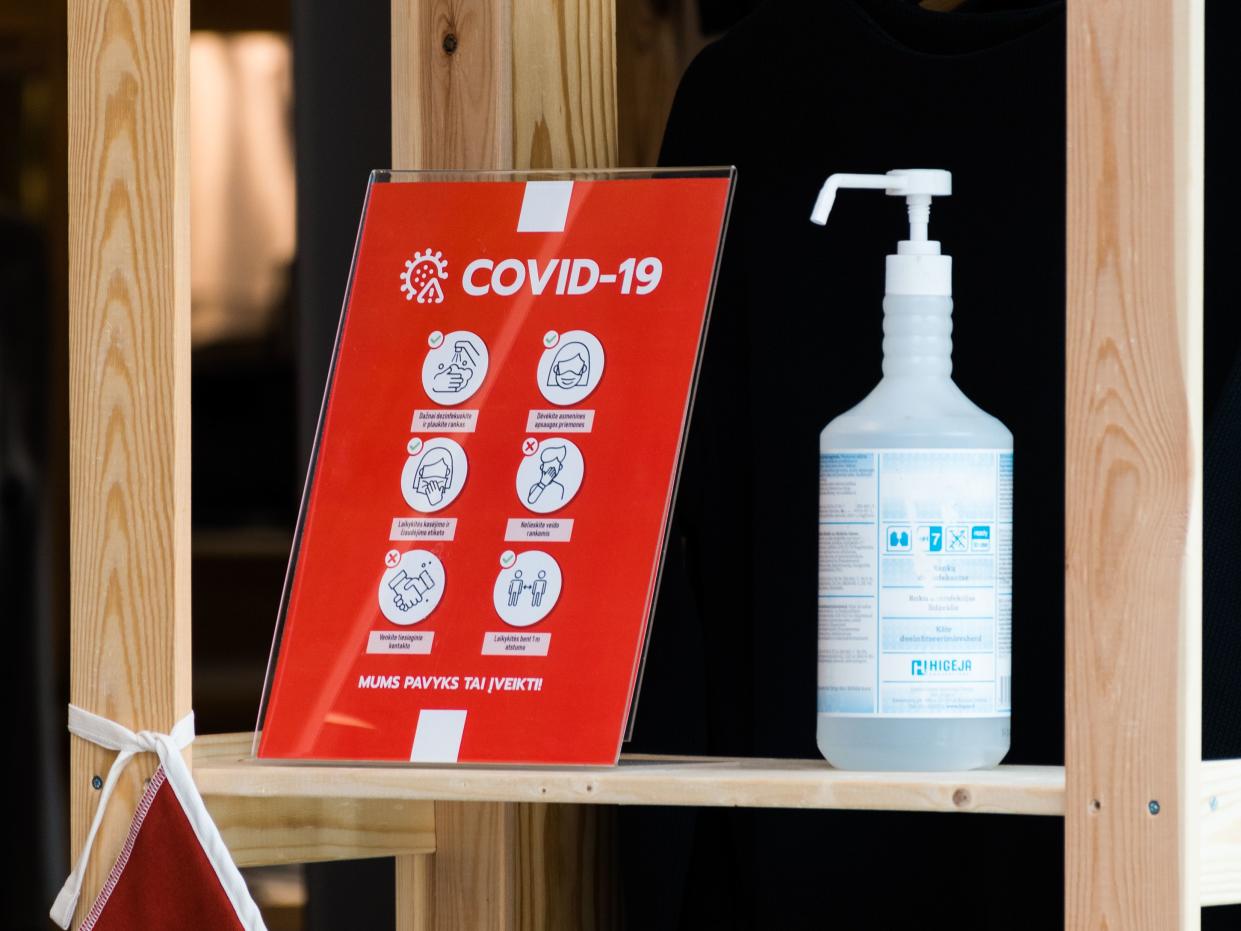 Guidance or signage with bottle of disinfectant for cleaning and disinfection and rules to follow for COVID-19 or Coronavirus emergency at the entrance of a store, shop, restaurant or school, precaution anti-Covid