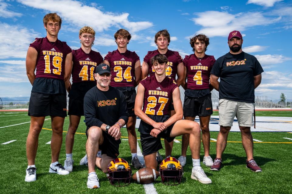 From left, top to bottom: Windsor players Gavyn Helm (19), Mikey Munn (41), Brady Lichtenberg (34), Zeb Mirriam (72), Kyle Phelps (4), assistant coach Michael Thompson, head coach Chris Jones and Henry Jones (27) take a group photo at the Coloradoan's high school football Media Day at PSD Stadium on August 1, 2023.