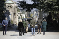 FILE - In this Tuesday, March 17, 2020 file photo, relatives walk behind a hearse carrying a coffin inside the Monumentale cemetery, in Bergamo, Italy. It was the biggest soccer game in Atalanta’s history and a third of Bergamo’s population made the short trip to Milan’s famed San Siro Stadium to witness it. Nearly 2,500 fans of visiting Spanish club Valencia also traveled to the Champions League match. More than a month later, experts are pointing to the Feb. 19 game as one of the biggest reasons why Bergamo has become one of the epicenters of the coronavirus pandemic — a “biological bomb” was the way one respiratory specialist put it — and why 35% of Valencia’s team became infected. The new coronavirus causes mild or moderate symptoms for most people, but for some, especially older adults and people with existing health problems, it can cause more severe illness or death. (AP Photo/Luca Bruno, File)