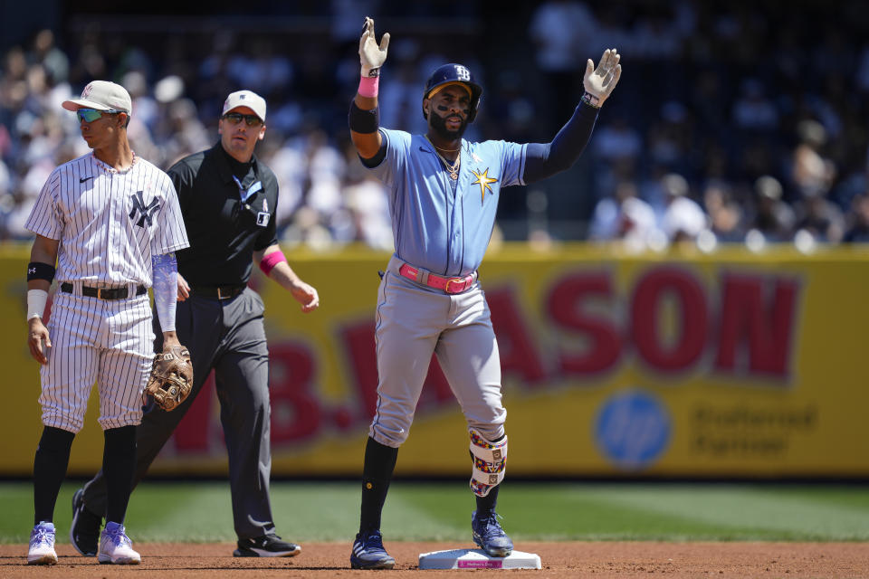 Tampa Bay Rays' Yandy Diaz, center, reacts after hitting a double off New York Yankees starting pitcher Clarke Schmidt in the first inning of a baseball game, Sunday, May 14, 2023, in New York. (AP Photo/John Minchillo)