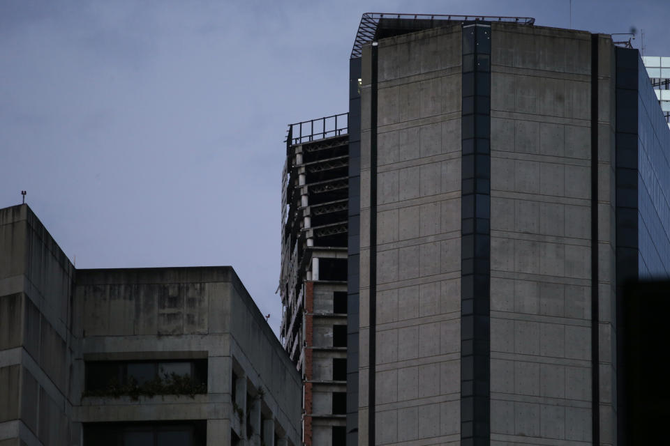 An abandoned, unfinished skyscraper known as "The Tower of David" shows an inclination on the top floors where the columns are exposed, top center, after a powerful earthquake shook eastern Venezuela, causing buildings to be evacuated in the capital of Caracas, Venezuela, Tuesday, Aug. 21, 2018. The quake was felt as far away as Colombia's capital and in the Venezuelan capital office workers evacuated buildings and people fled homes. (AP Photo/Ariana Cubillos)