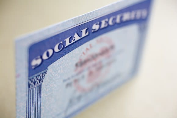 A Social Security card standing up on a table with the name and number on the card blurred out.