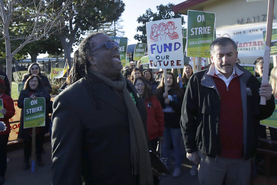 Oakland Education Association President Keith Brown, center left, yells after speaking outside of Manzanita Community School in Oakland, Calif., Thursday, Feb. 21, 2019. Teachers in Oakland, California, went on strike Thursday in the country's latest walkout by educators over classroom conditions and pay. (AP Photo/Jeff Chiu)