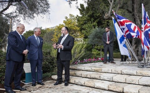 Charles plants a tree in the grounds of the official residence of Israeli President Reuven Rivlin watched on by Chief Rabbi Ephraim Mirvis - Credit: Getty