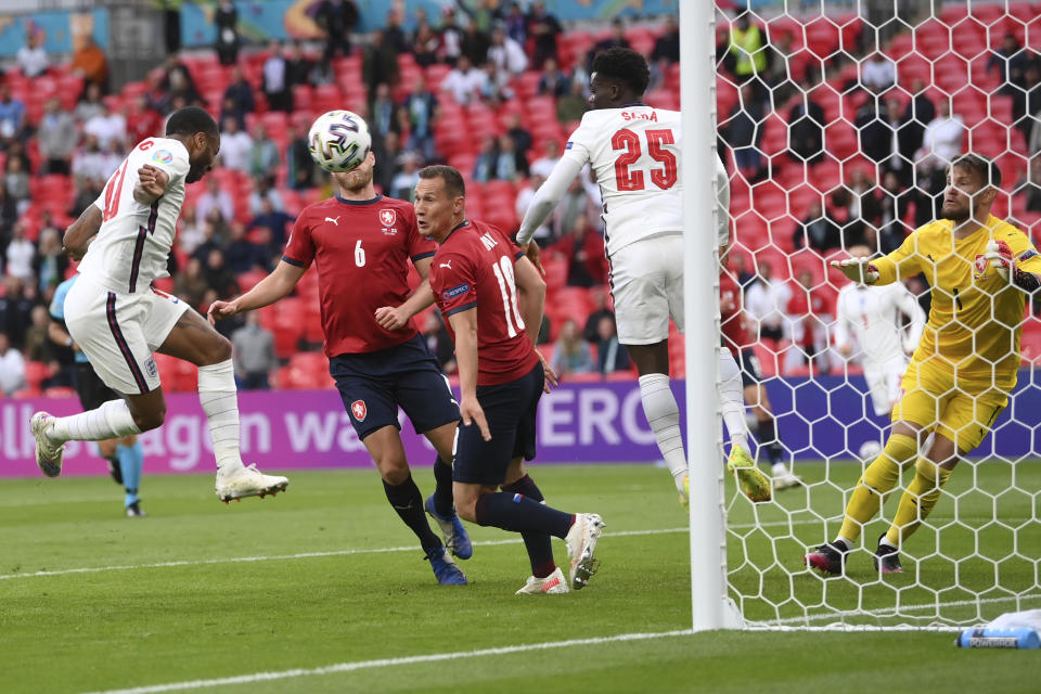 England's Raheem Sterling, left, scores his side's opening goal during the Euro 2020 soccer championship group D match between Czech Republic and England, at Wembley stadium in London, Tuesday, June 22, 2021. (AP Photo/Laurence Griffiths, Pool)