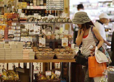 A woman looks at food products at a supermarket at a shopping district in Tokyo July 29, 2014. REUTERS/Yuya Shino