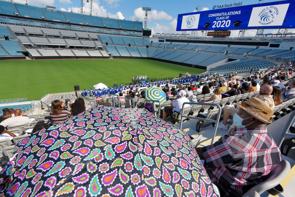 Spectators brought their own shade as they watched the graduation ceremony for the 2020 graduates of the Frank H. Peterson Academies of Technology from the stands of TIAA Bank Field Friday morning. Frank H. Peterson Academies of Technology held their coronavirus delayed graduation ceremony for the class of 2020 Friday, July 17, 2020 in the stands of TIAA Bank Field in Jacksonville, Florida. Parents and friends cheered on the graduates from the upper seating levels of the East side of the stadium while the masked and socially distanced graduates were seated below as they waited to approach the field level stage to pick up their diplomas. There were 260 graduates in the class of 2020 but many were not in attendance, having already moved on with their lives.