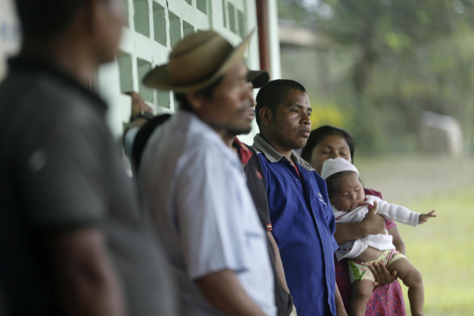 Residents gather in the remote jungle community of El Terron, Panama, Friday, Jan. 17, 2020. A pregnant woman, five of her children and a neighbor where round up by about 10 lay preachers at the hamlet on Monday and tortured, beaten, burned and hacked with machetes to make them "repent their sins", authorities said. (AP Photo/Arnulfo Franco)