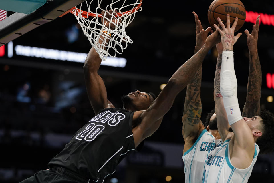 Charlotte Hornets forward Gordon Hayward, from left, reaches for a rebound against Charlotte Hornets center Nick Richards (4) and guard LaMelo Ball (1) in the first half of an NBA basketball game, Monday, Oct. 30, 2023, in Charlotte, N.C. (AP Photo/Erik Verduzco)