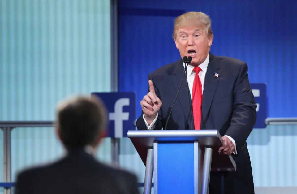 President Donald Trump on a podium with Facebook logo behind him.