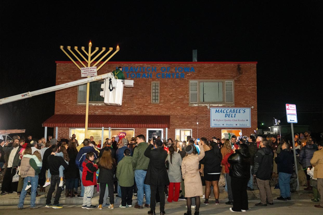 More than 100 people gather as they celebrate the lighting of the menorah Thursday, Dec. 7, 2023, at Maccabee's Deli in Des Moines.