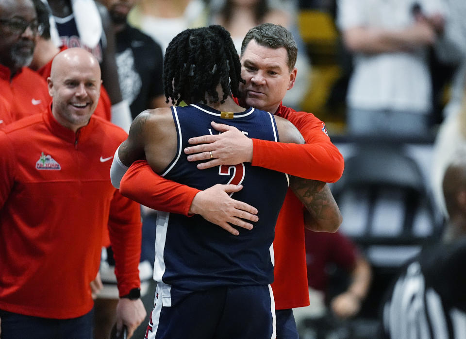 Arizona coach Tommy Lloyd, right, hugs guard Caleb Love, who was pulled during the second half of the team's NCAA college basketball game against Colorado on Saturday, Feb. 10, 2024, in Boulder, Colo. (AP Photo/David Zalubowski)