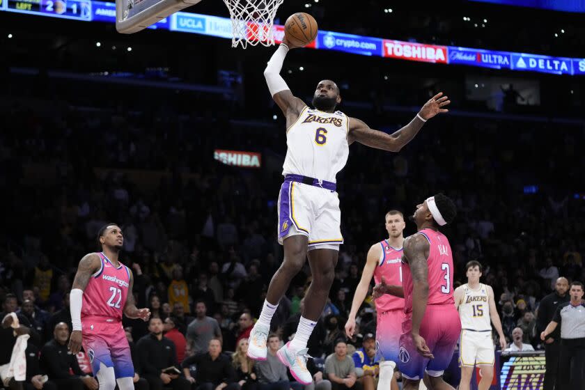 Los Angeles Lakers' LeBron James (6) goes up for a dunk as Washington Wizards' Bradley Beal.