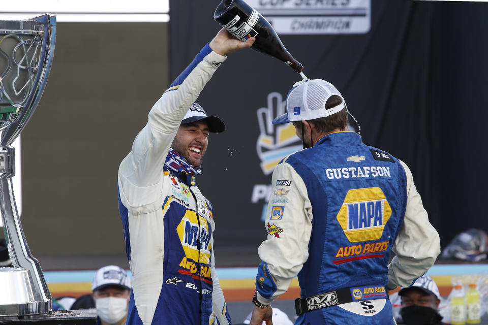 Chase Elliott, left, and pit crew chief Alan Gustafson celebrate their season championship in Victory Lane after winning a NASCAR Cup Series auto race at Phoenix Raceway, Sunday, Nov. 8, 2020, in Avondale, Ariz. (AP Photo/Ralph Freso)