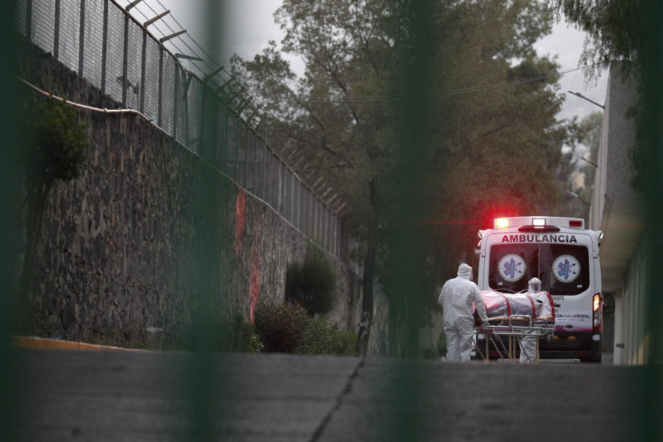 In this April 28, 2020 photo, ambulance workers unload a patient at a public hospital treating people with suspected COVID-19, in Iztapalapa, Mexico City. Concern is growing that early mixed messages about the seriousness of the pandemic from Mexico’s president and lax enforcement of social distancing, are manifesting in Iztapalapa first in what could be a frightening preview as infections begin to peak in the capital. (AP Photo/Rebecca Blackwell)