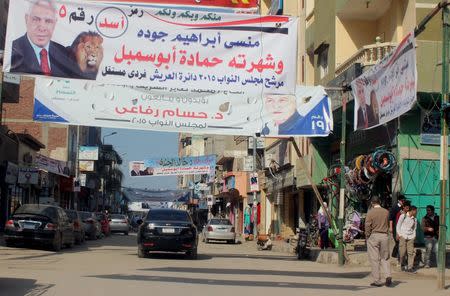 People and vehicles are seen under electoral banners ahead of the second round of parliamentary election, in Al Arish city, North Sinai, Egypt, November 19, 2015. REUTERS/Stringer