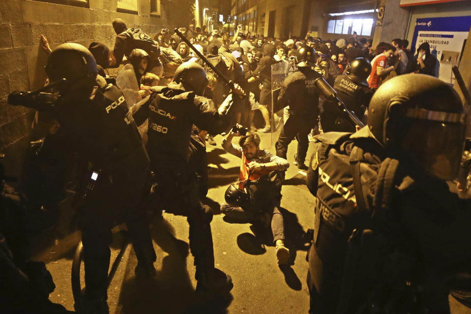 Un periodista cae al suelo durante el enfrentamiento entre mossos y manifestantes (AP Photo/Emilio Morenatti)