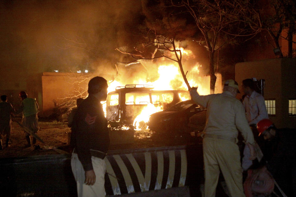 A police officer and rescue workers arrive at the site of bomb blast in Quetta, Pakistan, Wednesday, April 21, 2021. A powerful bomb went off in the parking area of a five-star Serena hotel in the southwestern city of Quetta on Wednesday, wounding some people, police said. (AP Photo/Arshad Butt)