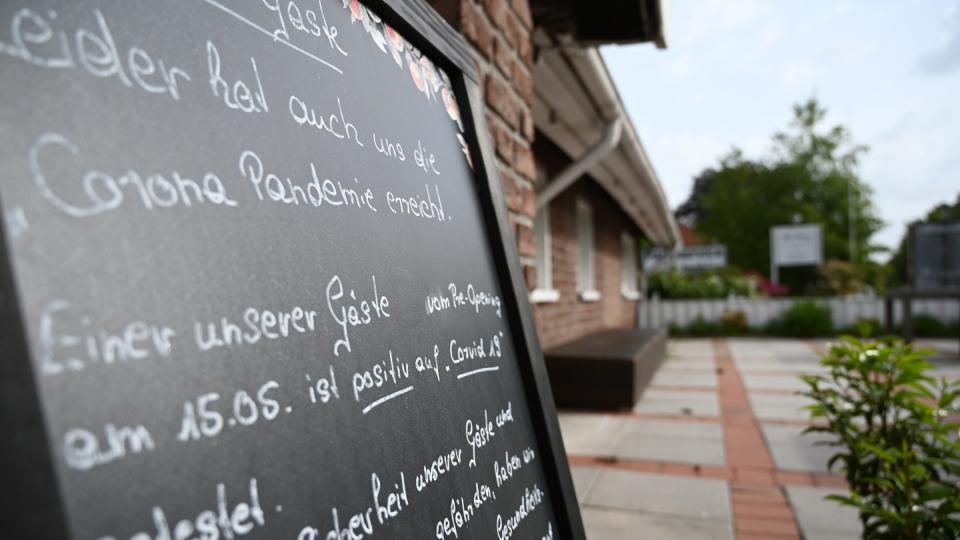 Ein Schild mit der Aufschrift «Leider hat auch uns die Corona Pandemie erreicht», steht vor dem Restaurant «Alte Scheune» in Moormerland.