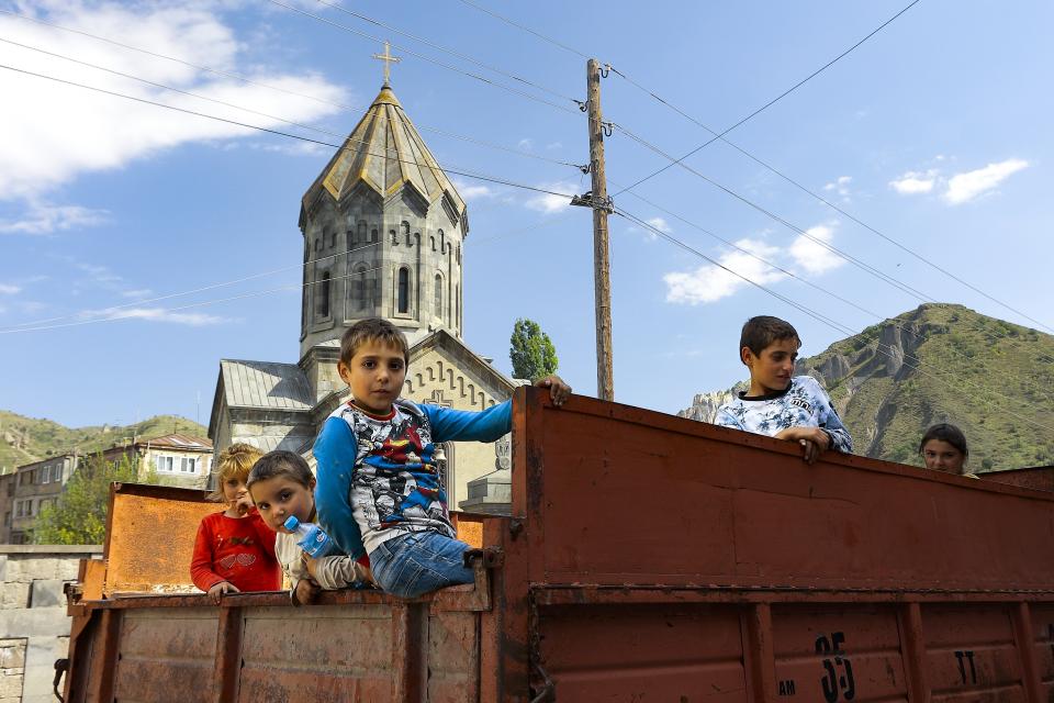 Ethnic Armenian children from Nagorno-Karabakh look from a truck after arriving in Armenia's Goris in Syunik region, Armenia, on Thursday, Sept. 28, 2023. The separatist government of Nagorno-Karabakh announced Thursday that it will dissolve itself and the unrecognized republic will cease to exist by the end of the year, and Armenian officials said more than half of the population has already fled. More than half of the region's population has already fled to Armenia, according to Armenian officials. (AP Photo/Vasily Krestyaninov)