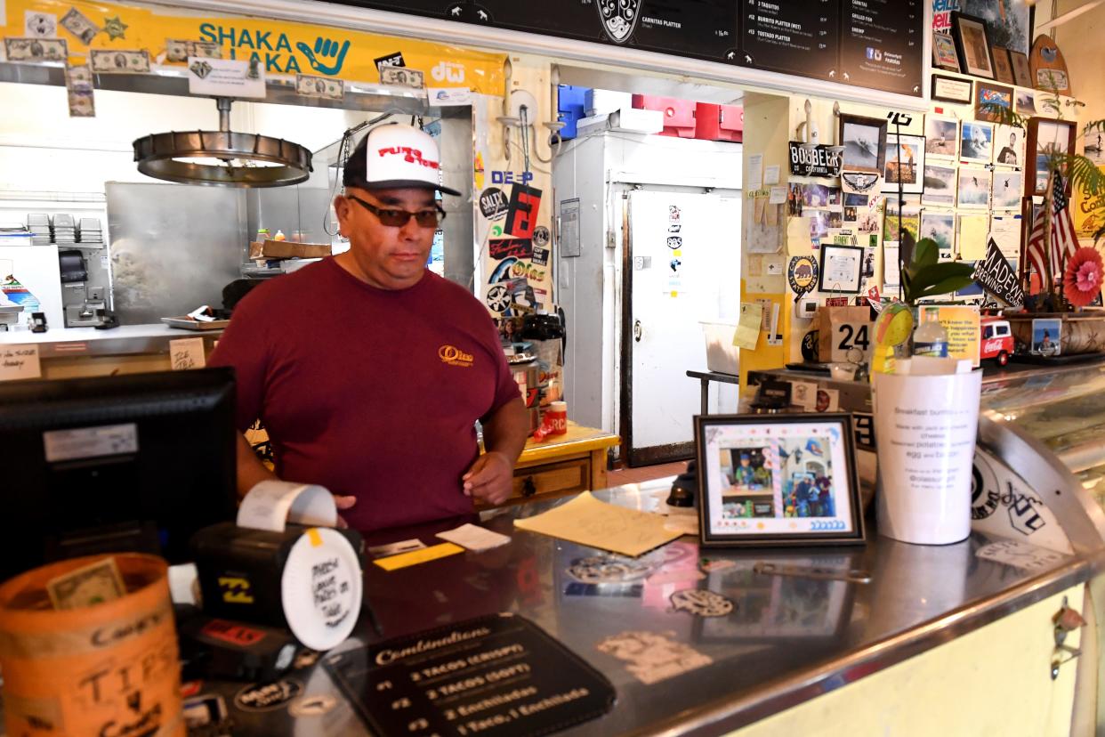 Carlos Reyes, Owner of Olas de Carlos Surf Grill in Camarillo, works the front counter at his restaurant on Tuesday, May 9, 2023. The eatery is the subject of a lawsuit alleging that the slope for its disabled access parking spot is out of compliance.