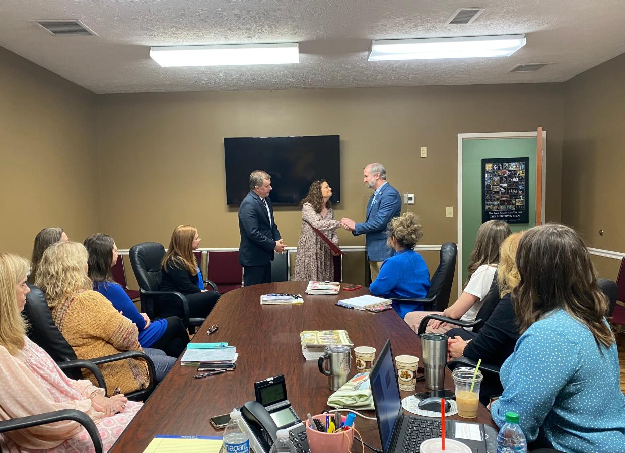 State Representatives Ron Gant (left) and Chris Todd (right) present Friday morning's proclamation honoring the Carl Perkins Center's 40th anniversary to Delaine Bottoms (middle), Vice President of the Center, while surrounded by the center's regional representatives.