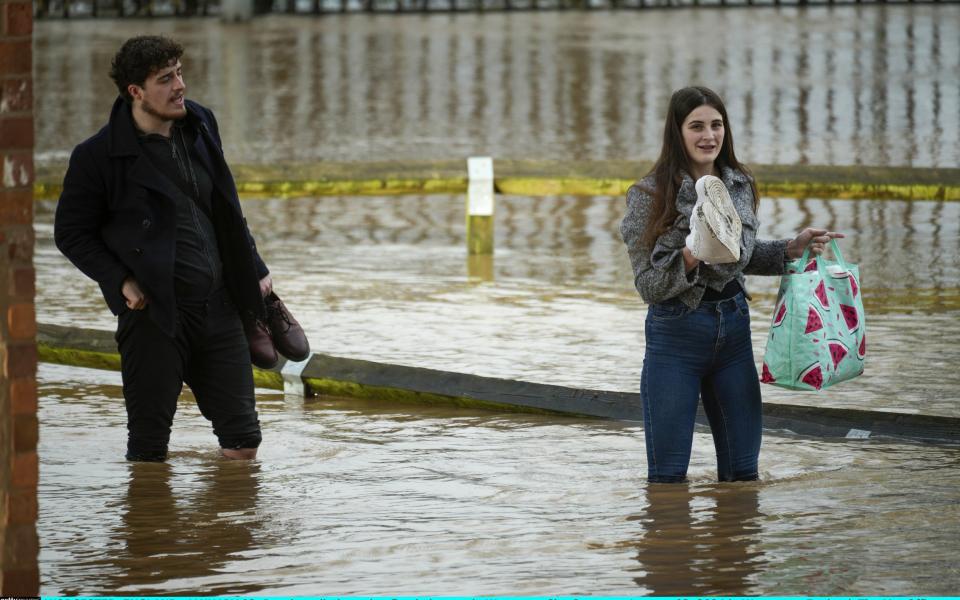 People tackle a flooded street in Worcester City Centre