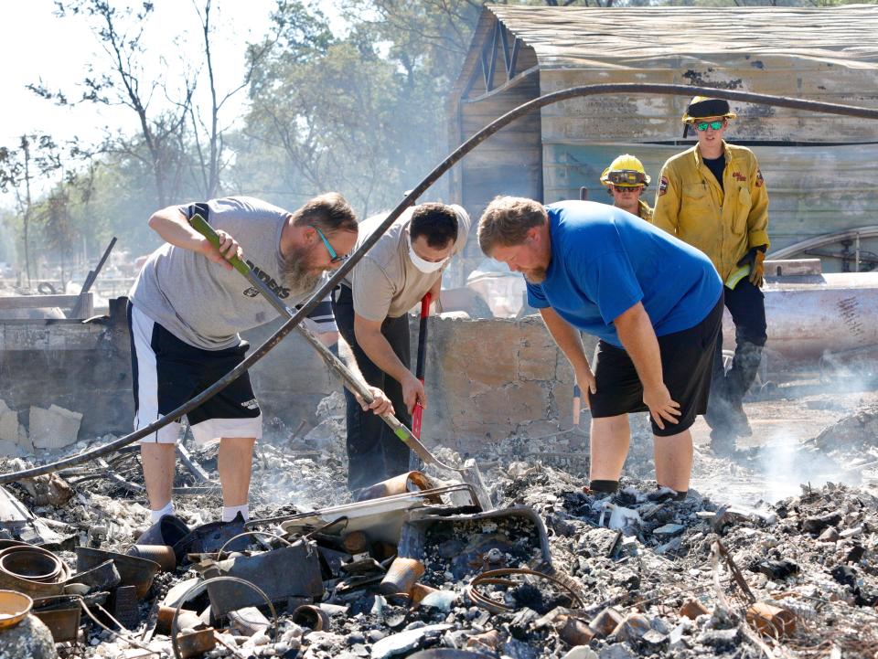 J.D. Krieger, right, looks for the urn that contains the ashes of his father, John Krieger, along with half-brother Tony Platz, left, and close friend Eddie McNamara on Friday morning, July 15, 2022. Minutes later they found the urn in the home that was destroyed in the Peter Fire.