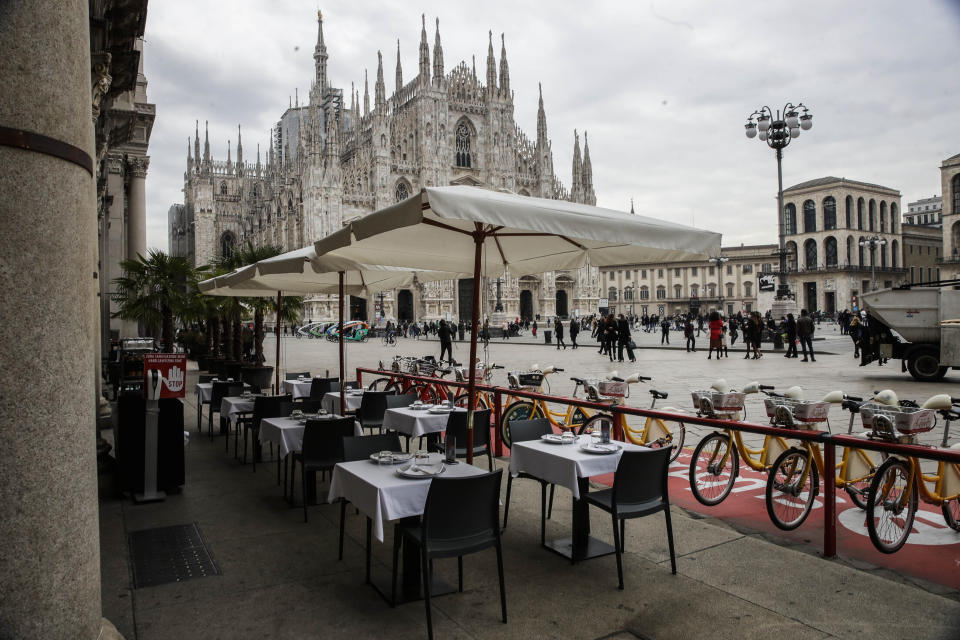 ARCHIVO - En esta imagen del miércoles 21 de octubre de 2020, mesas vacías en un restaurante en la Plaza del Duomo en Milán, Italia. Un rebrote del nuevo coronavirus está asestando un segundo golpe a los restaurantes europeos, que ya sufrieron durante las cuarentenas de primavera. Desde Irlanda del Norte a Holanda, los gobiernos europeos han cerrado los restaurantes o reducido mucho su actividad. (AP Foto/Luca Bruno, Archivo)