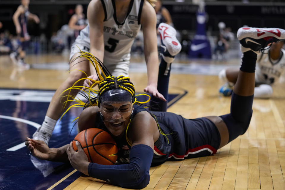 UConn forward Aaliyah Edwards (3) dives to save a loose bal under Butler guard Shay Frederick (5) during the second half of an NCAA college basketball game in Indianapolis, Tuesday, Jan. 3, 2023. (AP Photo/Michael Conroy)