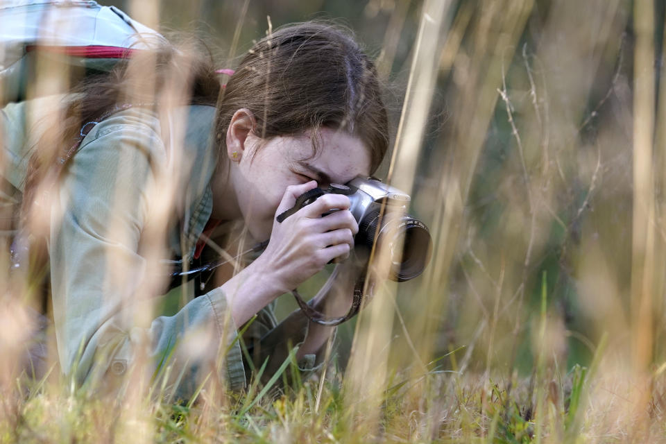 Olivia Chaffin makes photographs in a wooded area as she works on a Girl Scout photography merit badge in Jonesborough, Tenn., on Sunday, Nov. 1, 2020. (AP Photo/Mark Humphrey)