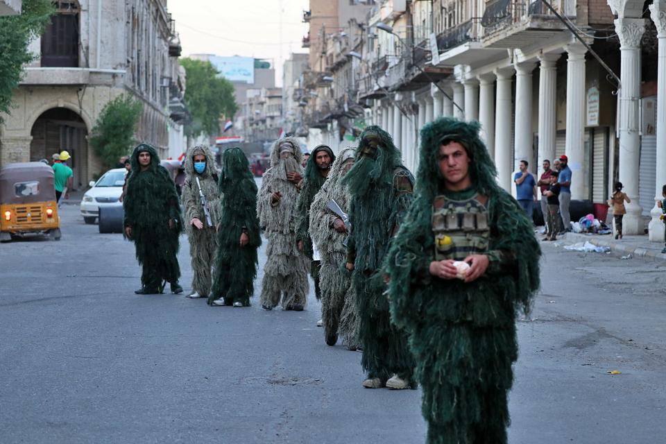 Anti-government protesters wear camouflage sniper uniforms during anti-government protests in Baghdad, Iraq, Tuesday, Nov. 5, 2019. (AP Photo/Hadi Mizban)