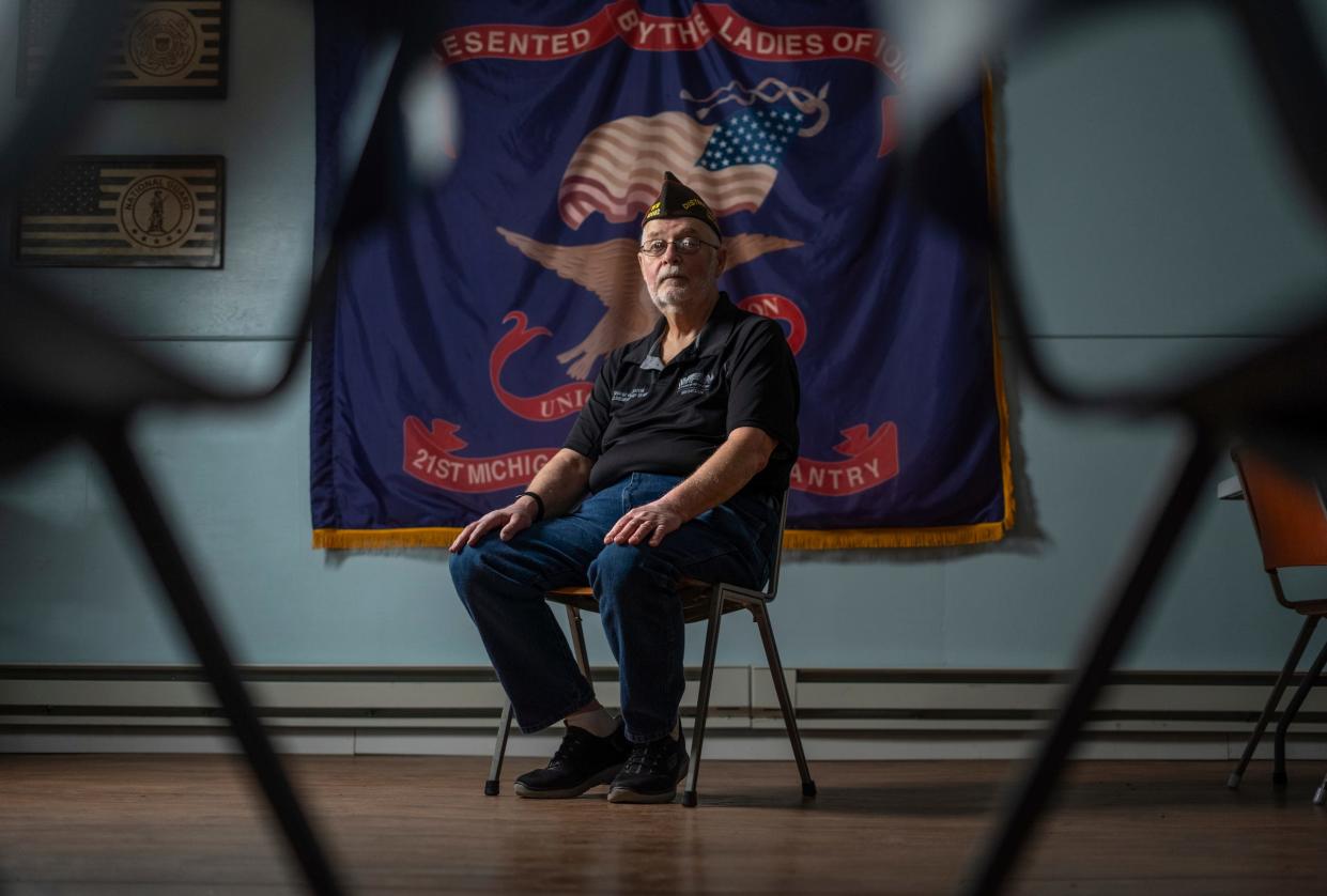 Ionia VFW Post 12082 quartermaster Shane Houghton sits in front of a replica of a Civil War battle flag once carried by the 21st Michigan Infantry, which he displays inside his VFW post in Ionia on Tuesday, Feb. 27, 2024.