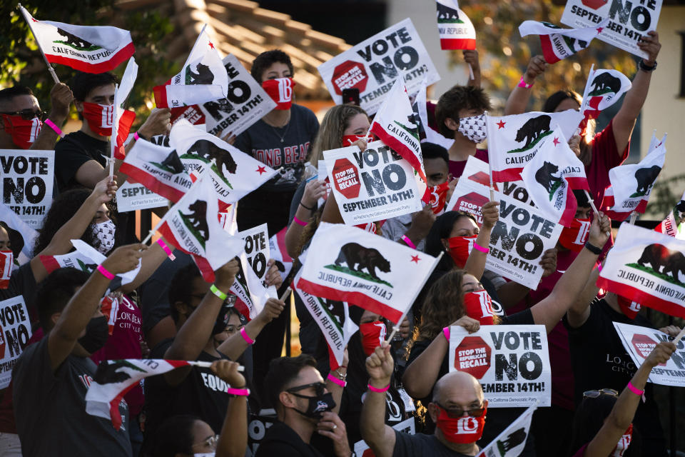 Supporters of California Gov. Gavin Newsom wave signs and California flags while waiting for the arrival of the governor and President Joe Biden at a rally Monday, Sept. 13, 2021, in Long Beach, Calif. (AP Photo/Jae C. Hong)