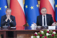 Poland's Prime Minister Donald Tusk, left, and President Andrzej Duda attend a meeting of the Cabinet Council, a consultation format between the president and the government, in Warsaw, Poland, on Tuesday Feb. 13, 2024. Tusk said Tuesday he has documentation proving that state authorities under the previous government used powerful Pegasus spyware illegally and that list of victims" was "very long ". (AP Photo/Czarek Sokolowski)