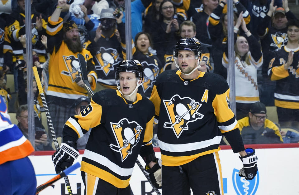 Jake Guentzel (59) is greeted by Brian Dumoulin (8) after scoring against the New York Islanders during the second period of an NHL hockey game Thursday, April 14, 2022, in Pittsburgh. (AP Photo/Keith Srakocic)