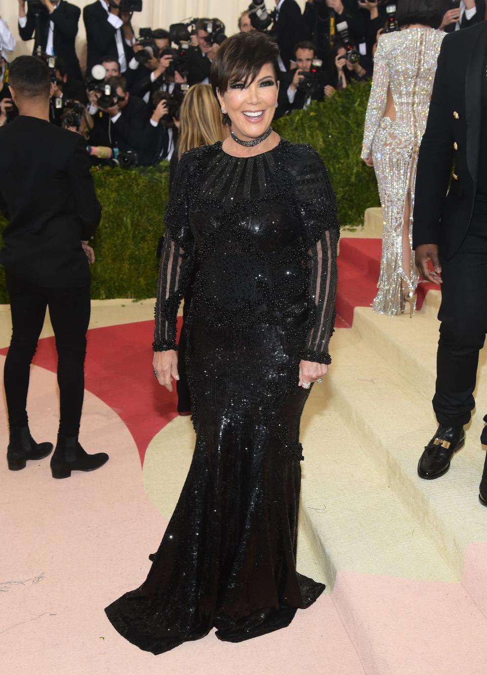 Kris Jenner poses for photos on the 2016 Met Gala red carpet wearing a shimmery black gown.