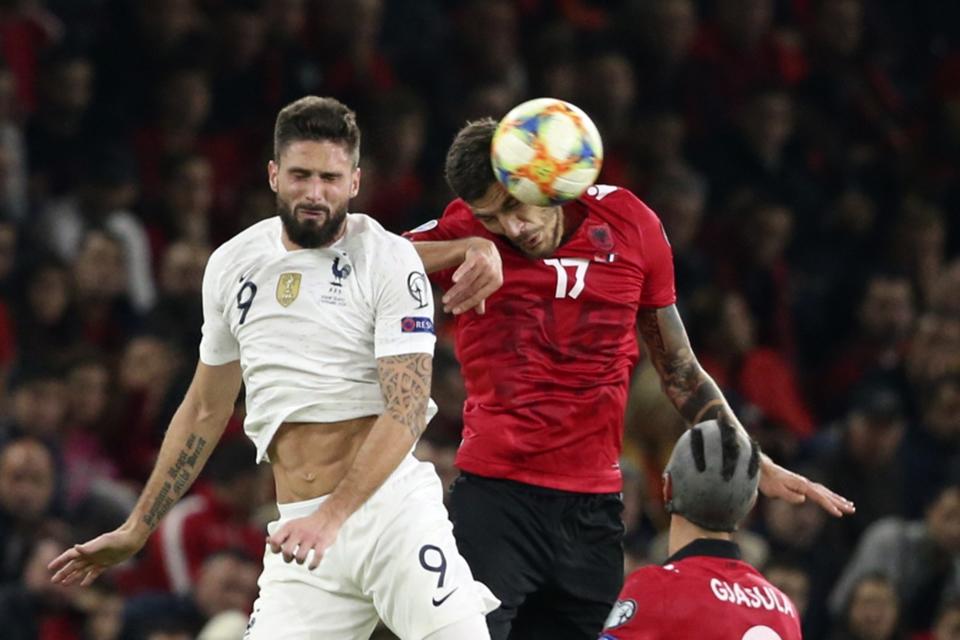 France's Olivier Giroud, left, and Albania's Kastriot Dermaku jump for the ball during the Euro 2020 group H qualifying soccer match between Albania and France at Arena Kombetare stadium in Tirana, Sunday, Nov. 17, 2019. (AP Photo/Hektor Pustina)