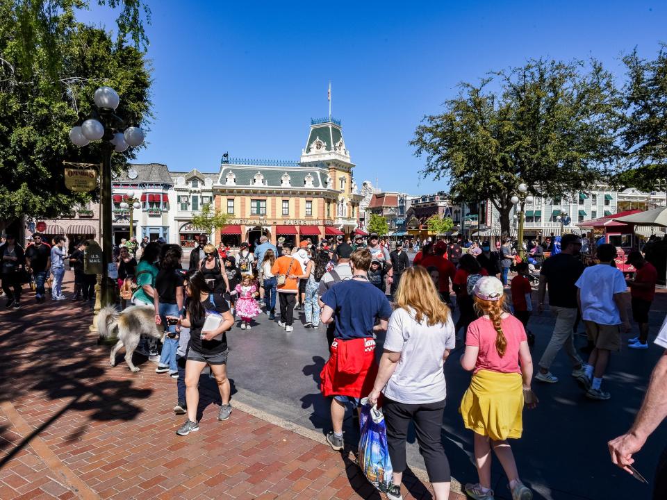 crowds of people in front of main street usa in disneyland