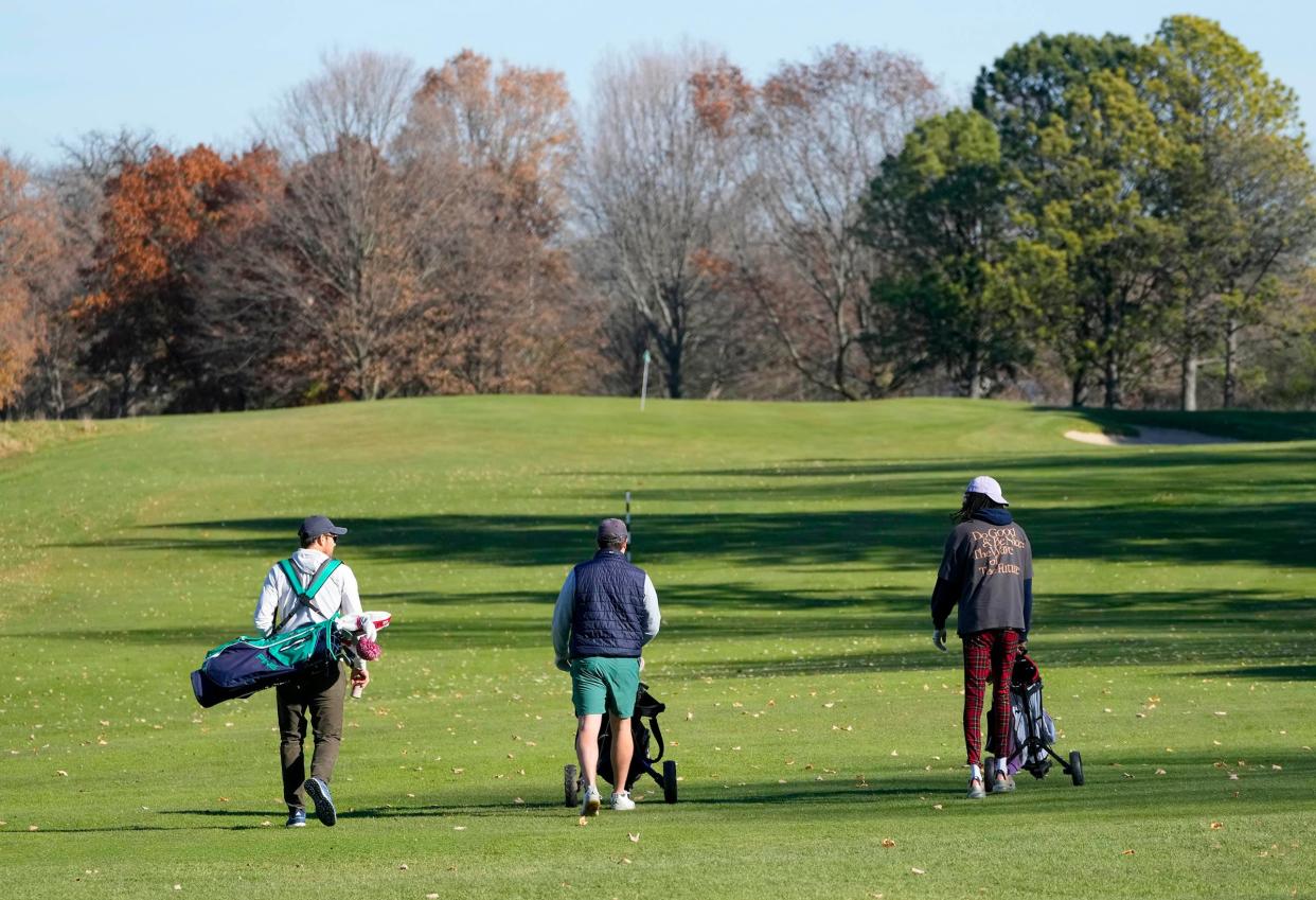 (From left) Bryan Wilson, Ian Trice both of Wauwatosa, and Shannon Jackson, of Menomonee Falls, walk along the fairway of the 7th hole after teeing off at Lincoln Park Golf Course in Glendale on Tuesday, Nov. 14, 2023. An unusually warm stretch of autumn weather has given golfers across southeastern Wisconsin a last chance to get in their final rounds of the year before the snow flies.