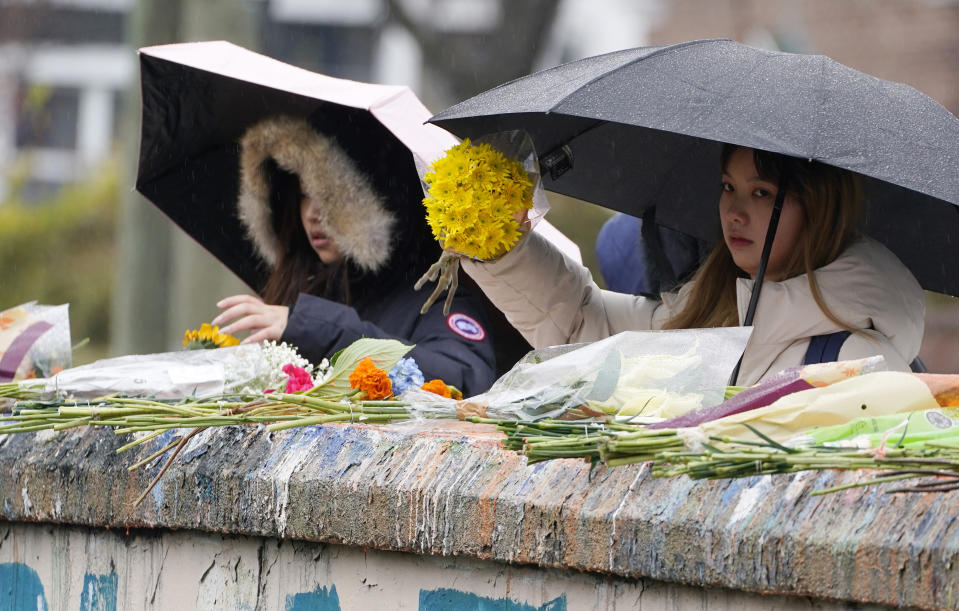 Mourners place flowers on a bridge near the scene of a shooting on the grounds of the University of Virginia Tuesday Nov. 15, 2022, in Charlottesville. Va. Authorities say three people have been killed and two others were wounded in a shooting at the University of Virginia and a student suspect is in custody. (AP Photo/Steve Helber)