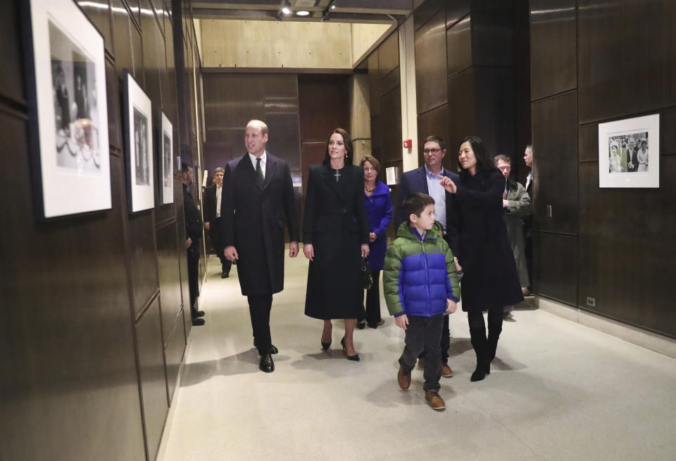 Boston Mayor Michelle Wu, right, and her family show photographs of Queen Elizabeth II's visit in 1976, during the visit of Britain's Prince William, left, and Kate, Princess of Wales, to Boston City Hall on Wednesday, Nov. 30, 2022, in Boston. The Prince and Princess of Wales are making their first overseas trip since the death of Queen Elizabeth II in September. (Nancy Lane/The Boston Herald via AP, Pool)