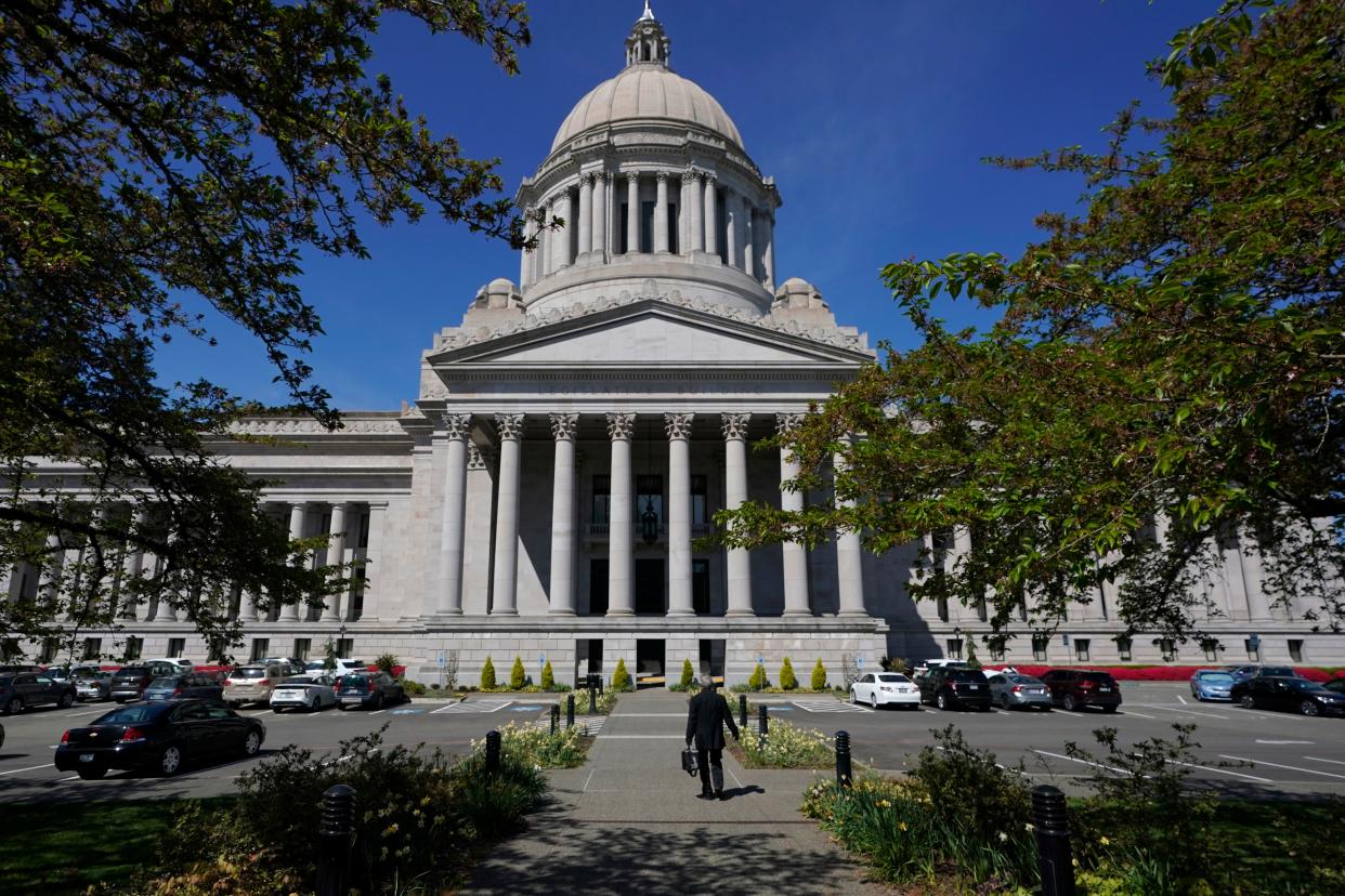 FILE - A person walks near the Legislative Building, Wednesday, April 21, 2021, at the Capitol in Olympia, Wash. Washington's redistricting commission failed to meet its deadline and on Tuesday, Nov. 16, kicked the job of creating new political maps to the state Supreme Court. The bipartisan commission had a deadline of 11:59 p.m. Monday to approve new boundaries for congressional and legislative districts following the 2020 census. (AP Photo/Ted S. Warren, File)