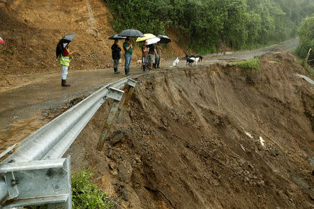 Residents look ta road partially collapsed by heavy rains of Tropical Storm Nate that affects the country in El Llano de Alajuelita, Costa Rica October 5, 2017. REUTERS/Juan Carlos Ulate