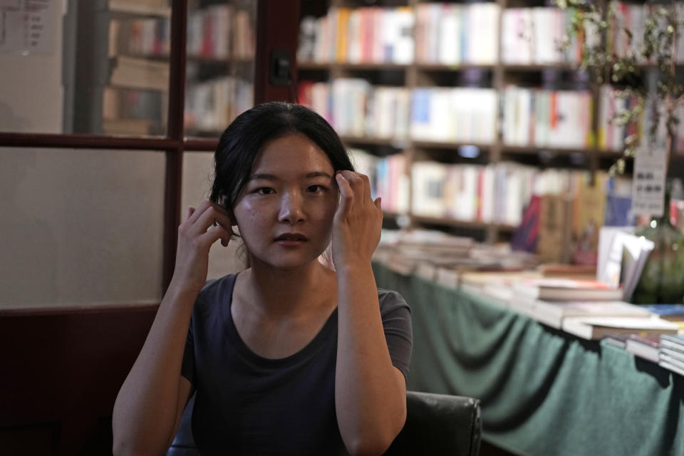 Chai Yujia tidies her hair as she poses for photos at a bookstore that specialises in feminist literature in Beijing, Sunday, Aug. 20, 2023. Aspiring to follow in Chizuko Ueno's footsteps to drive social change, university student Chai Yujia interned in a gender-focused NGO and helped facilitate the development of other feminist groups. (AP Photo/Ng Han Guan)