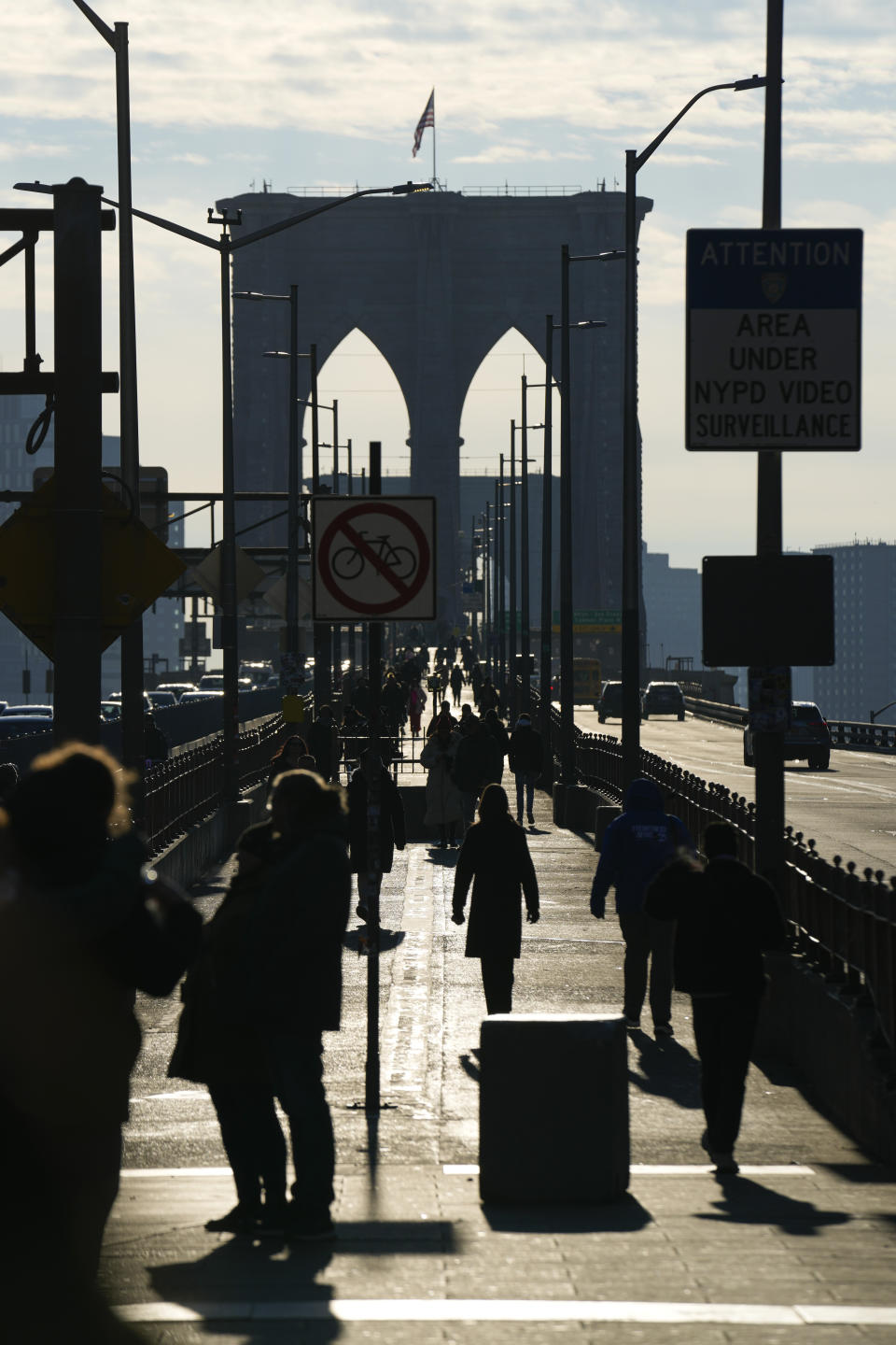 Pedestrians walk on the Brooklyn Bridge in New York, Wednesday, Jan. 3, 2024. New York City has banned vendors from the Brooklyn Bridge starting Wednesday. The move is intended to ease overcrowding on the famed East River crossing, where dozens of souvenir sellers competed for space with tourists and city commuters. (AP Photo/Seth Wenig)