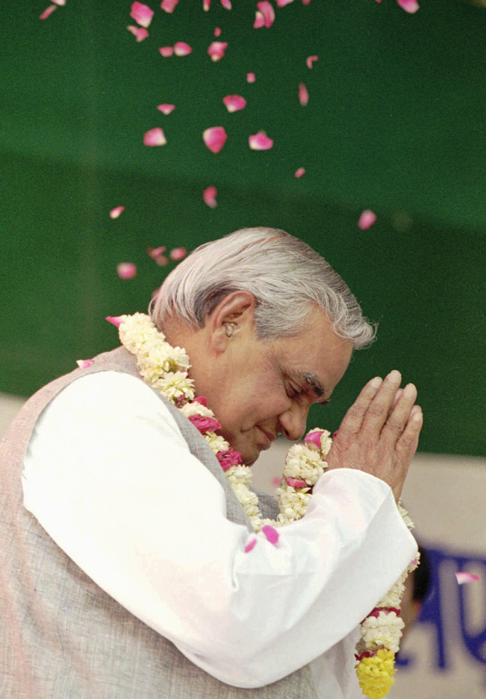 FILE - In this April 25, 1996 file photo, the Hindu nationalist party candidate for Prime Minister Atal Bihari Vajpayee greets supporters and is showered with rose petals at a campaign rally in New Delhi, India. Former prime minister Vajpayee, who pursued both nuclear weapons and peace talks with Pakistan, died Thursday, Aug. 16, 2018, at age 93. (AP Photo/John Moore, File)