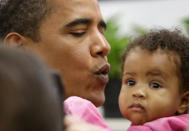 President-elect Barack Obama holds a child as he stops to eat in Ben's Chili Bowl with Washington Mayor Adrian Fenty in Washington, Saturday, Jan. 10, 2009. (AP Photo/Gerald Herbert)